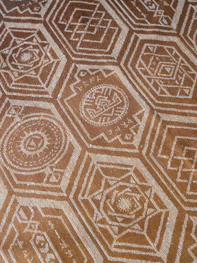 Close-up of a patterned fabric with geometric design in brown and beige.