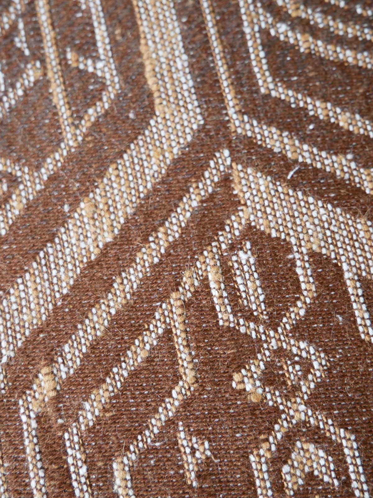 Close-up of a textured brown fabric with a subtle pattern