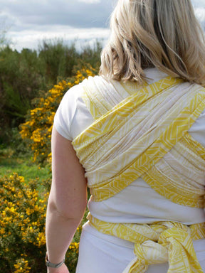 Woman wearing a yellow woven wrap with geometric pattern
