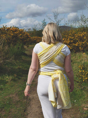 Woman wearing a yellow woven wrap with geometric pattern