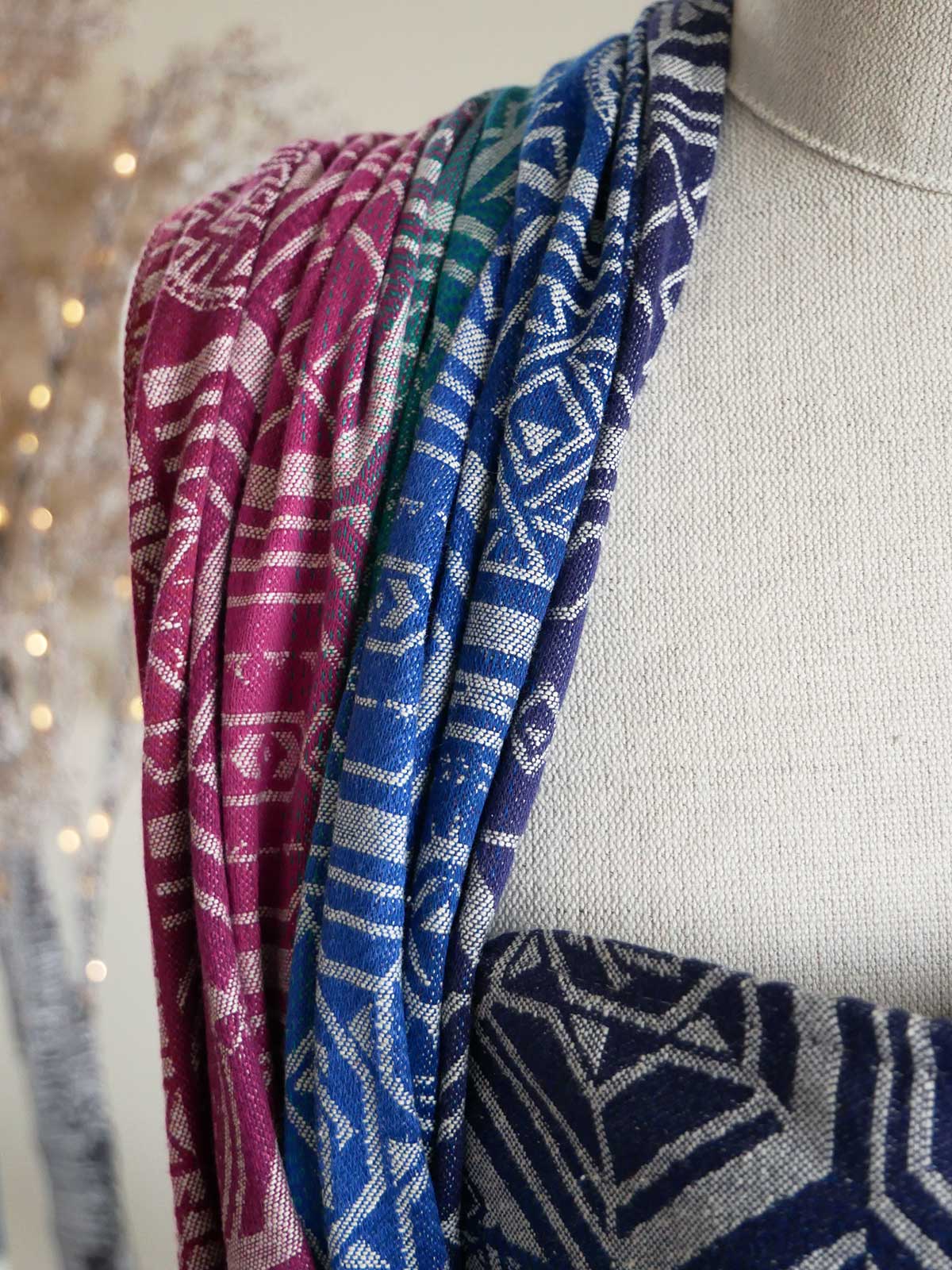 Close up of a jewel coloured fabric on a mannequin with geometric pattern.