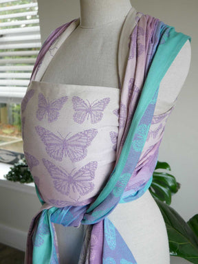 Mannequin wearing a woven wrap with butterfly pattern in a home setting