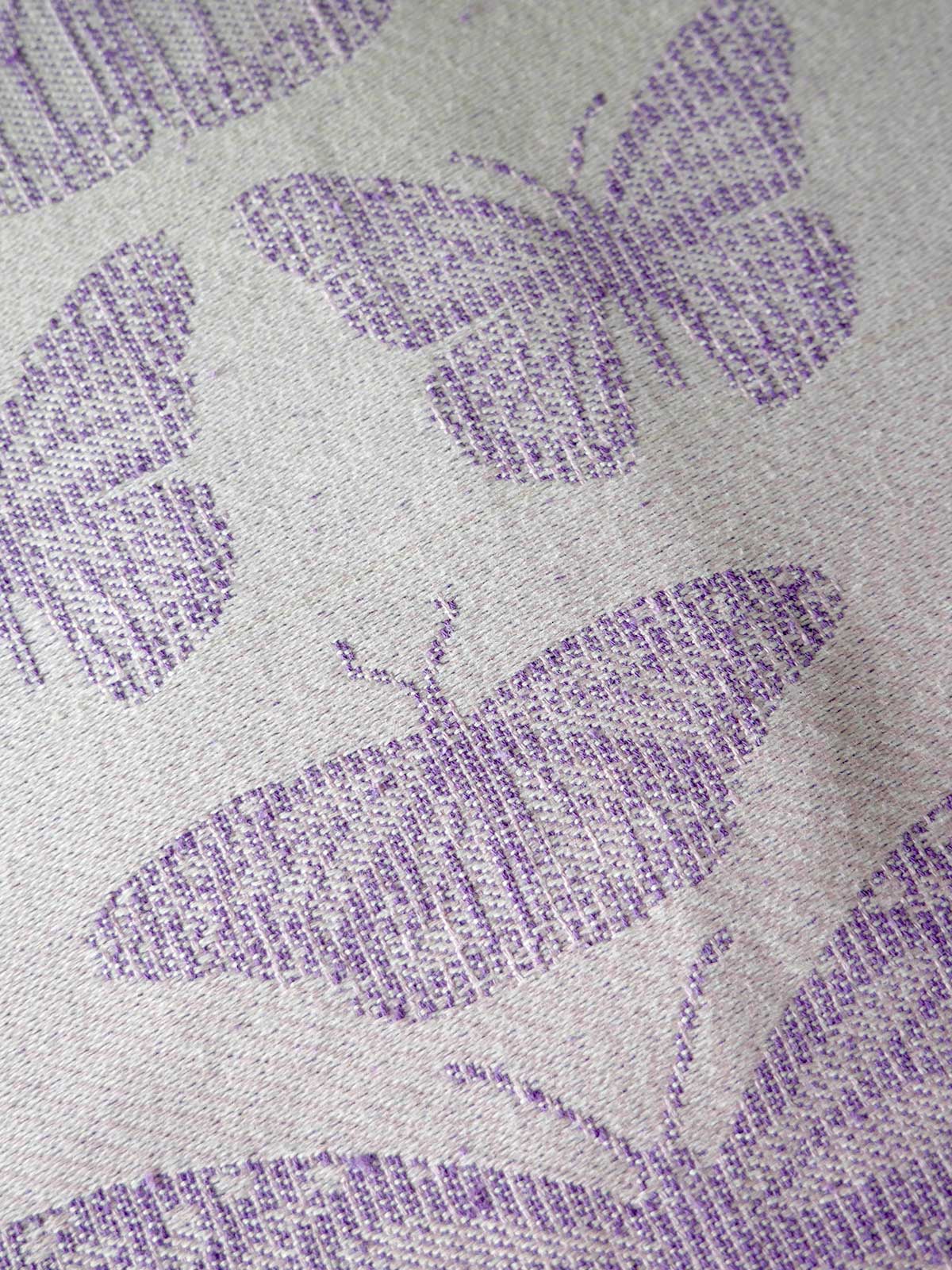 Close-up of fabric with purple butterfly pattern on gray background