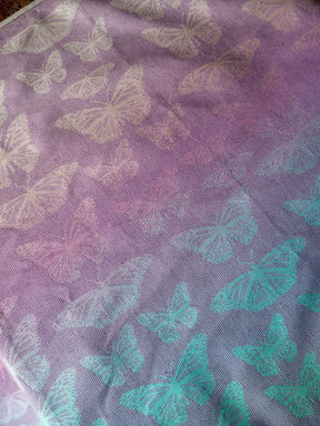 Fabric with butterfly pattern on a purple and teal gradient background