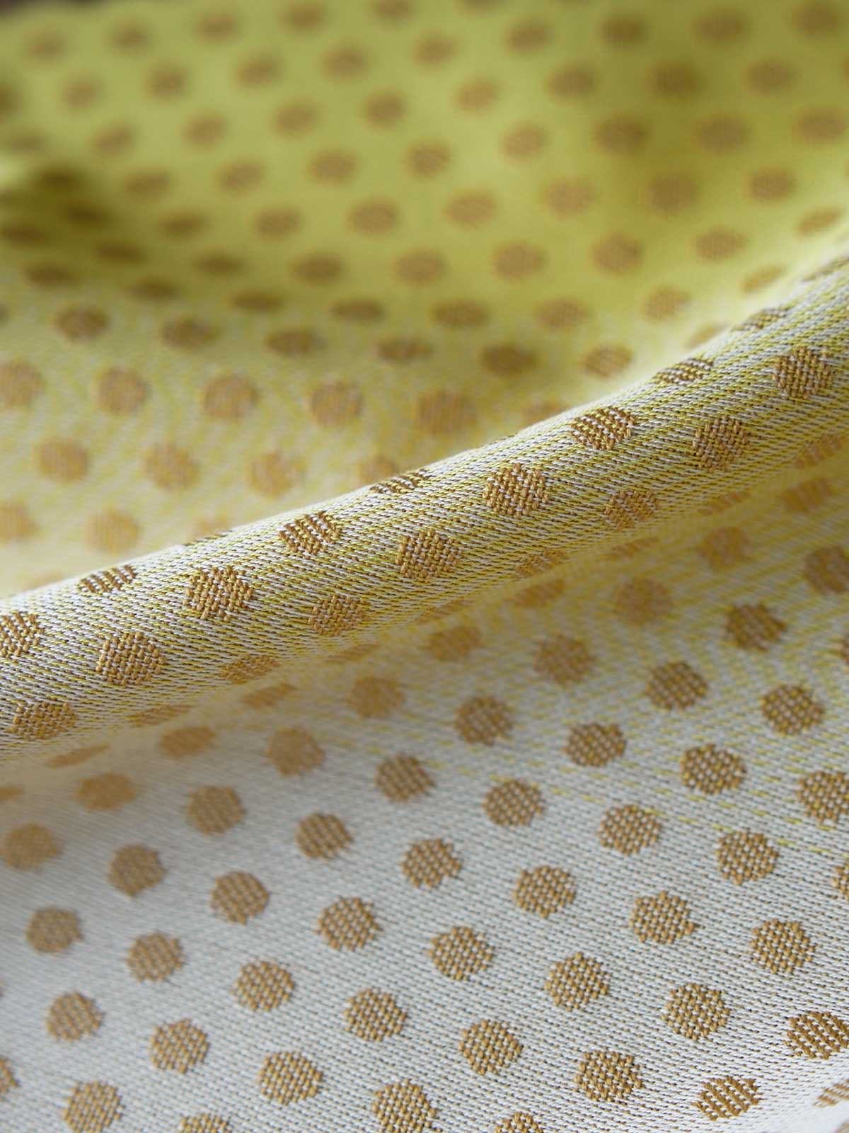 Close up of lemon and gold fabric with dots.