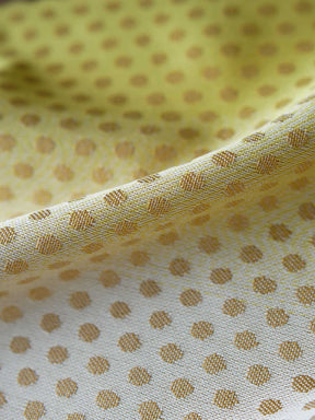 Close up of lemon and gold fabric with dots.