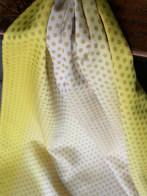 Lemon and gold fabric with dots flowing off a table.