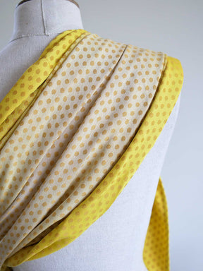 Close up of a lemon and gold ring sling with dots on a mannequin.