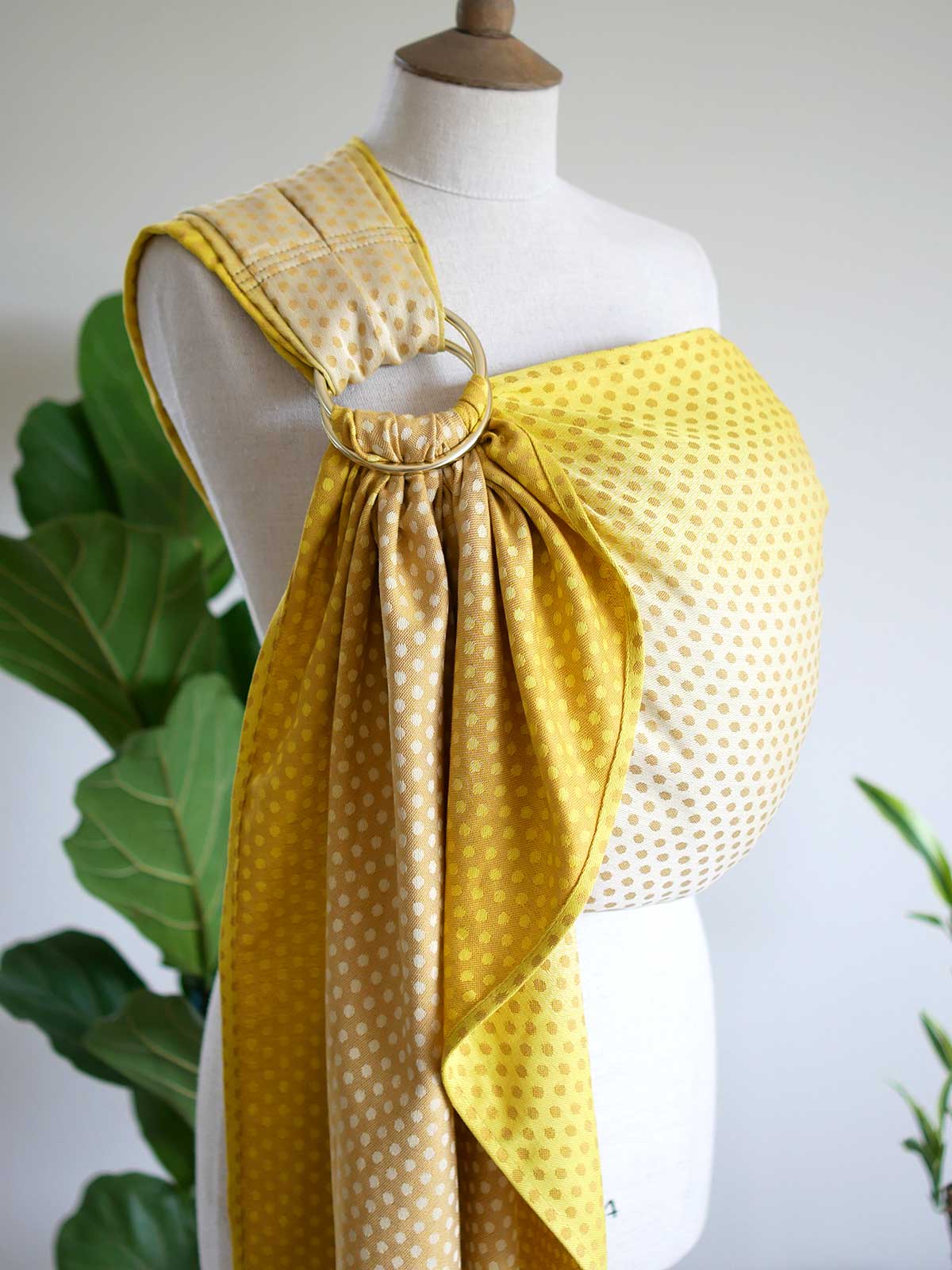 Side view of a lemon and gold ring sling with dots on a mannequin.