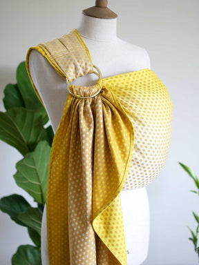 Side view of a lemon and gold ring sling with dots on a mannequin.
