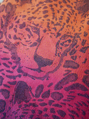 Close up of  fabric with a leopard face in pink.