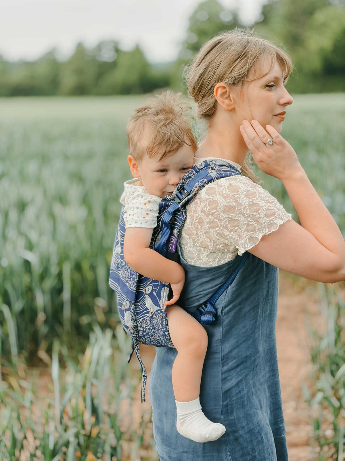 Side view of model wearing Onbuhimo baby carrier. 