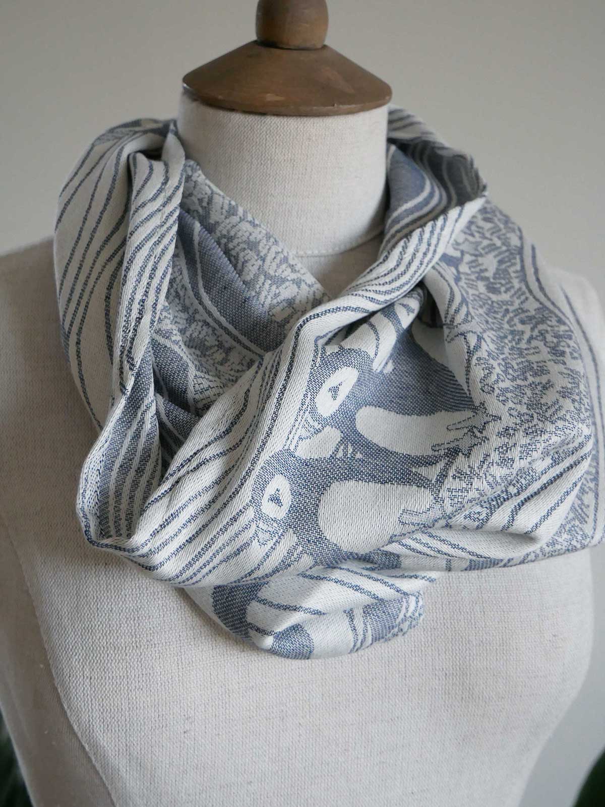 Scarf with bird pattern on a mannequin against a neutral background