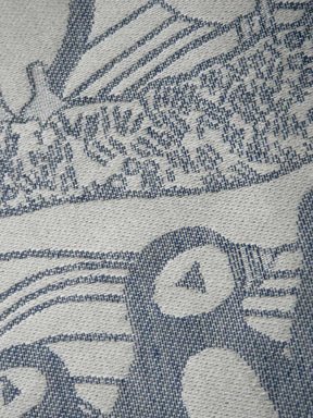 Close-up of a textured fabric with a pattern of puffins and lines.