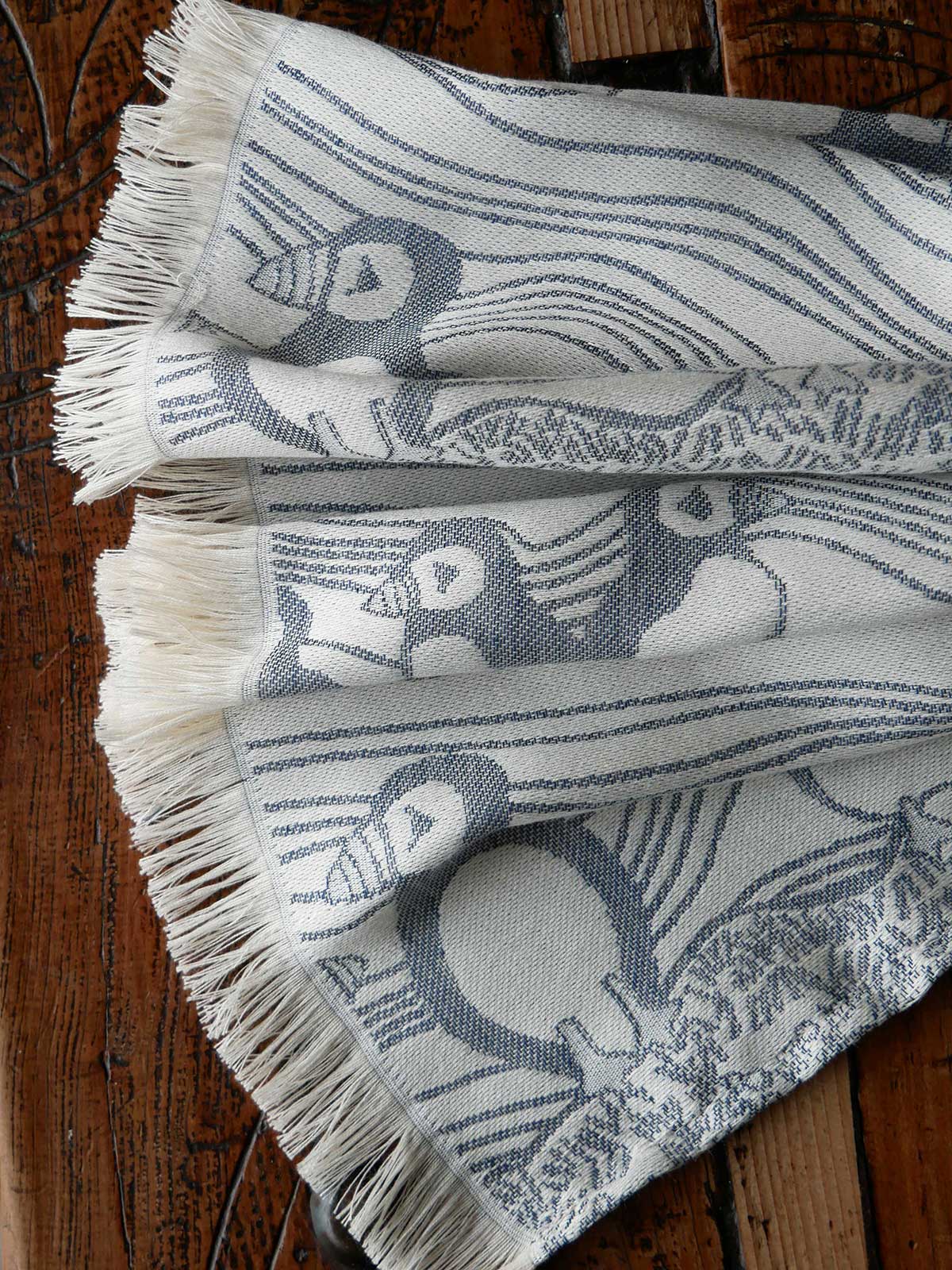 Textile with bird pattern on a wooden surface