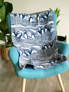 Baby blanket with puffin pattern sitting on a chair