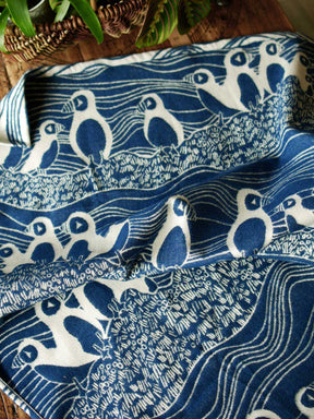 Reverse side of white and blue blanket with puffin pattern