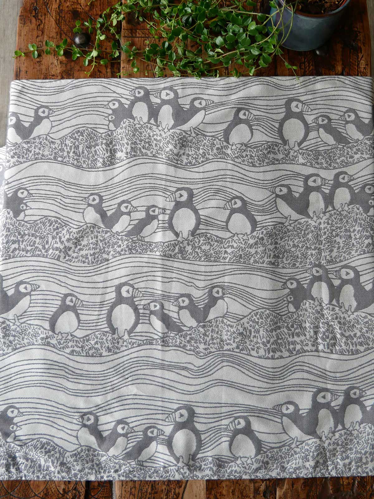 Textile with puffin pattern on a wooden surface