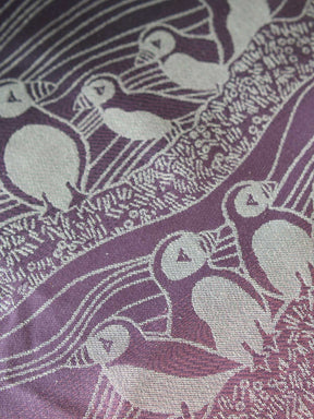 Close up of pink and purple fabric with puffin pattern