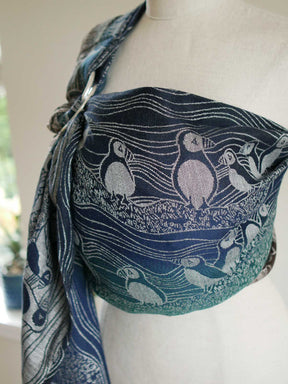 Side view of blue and green ring sling with puffin design on a mannequin.