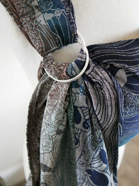 Close up of a silver ring on a blue ring sling on a mannequin
