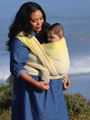 Woman with a baby in a yellow woven wrap.