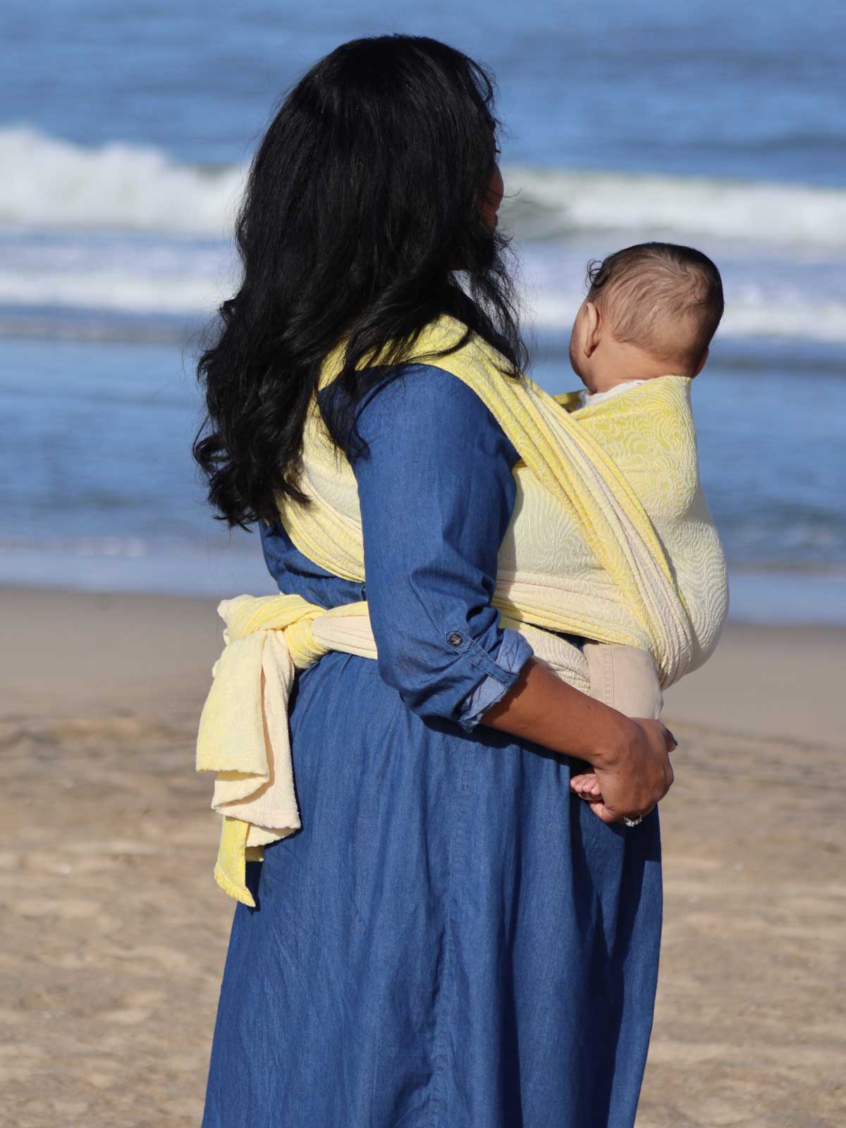 Woman with a baby in a yellow woven wrap.
