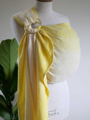 Yellow ring sling on a mannequin with swirling pattern.