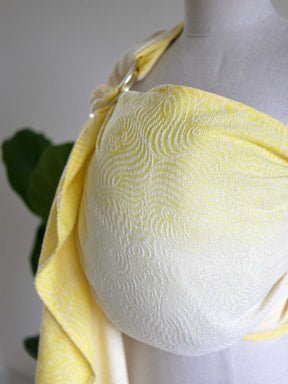 Yellow ring sling on a mannequin with swirling pattern.