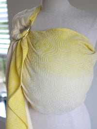 Yellow ring sling on a mannequin with swirling pattern.