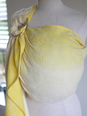 Yellow ring sling on a mannequin with swirling pattern.