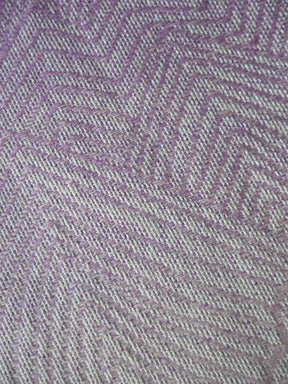 Close-up of a textured fabric with a zigzag pattern in shades of purple and gray.