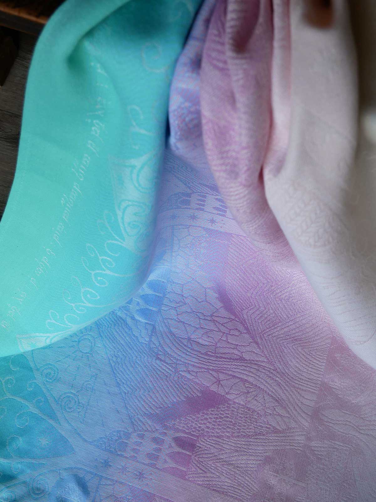 Close-up of a textured fabric with a pattern, showing a gradient from green to pink.