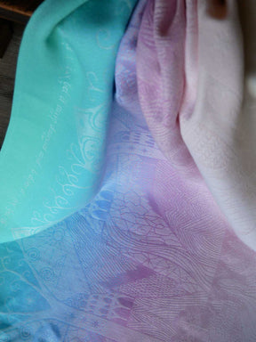 Close-up of a textured fabric with a pattern, showing a gradient from green to pink.