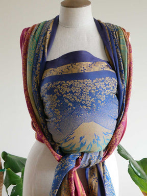 Mannequin wearing a colourful floral-patterned woven wrap with a plain background