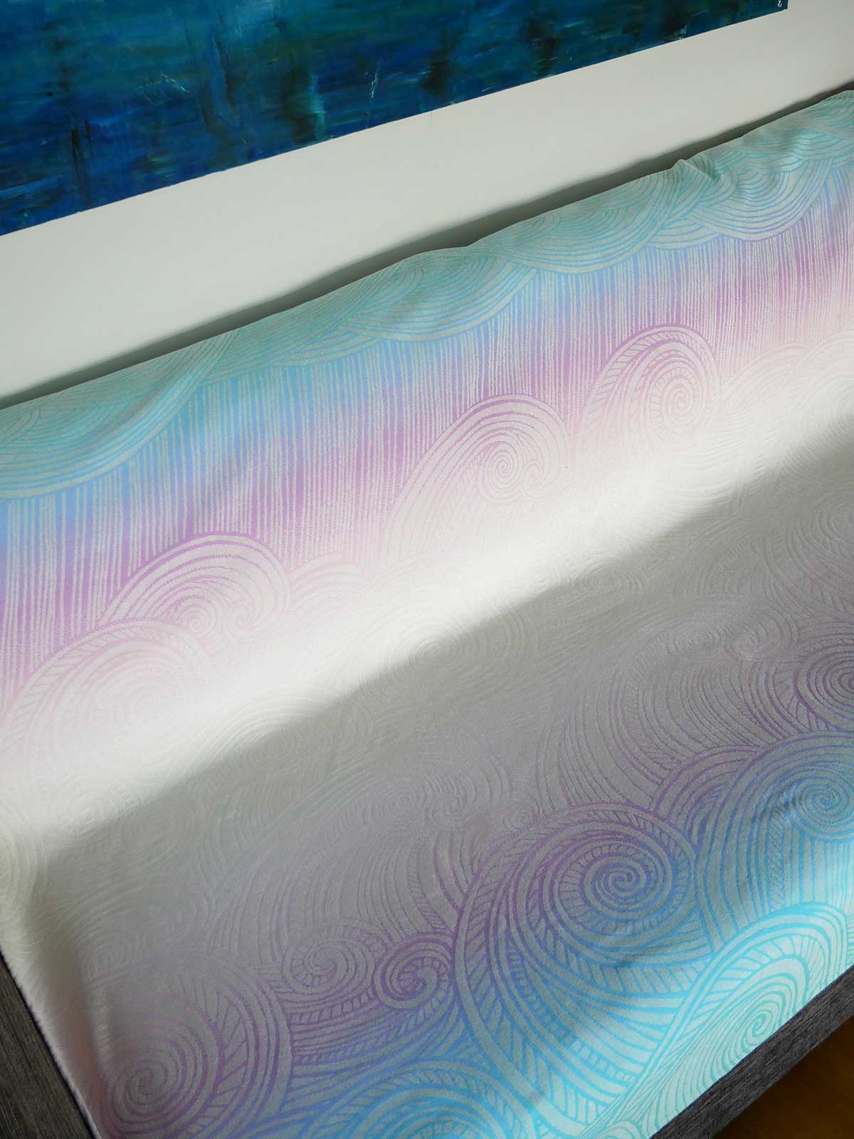 Close-up of a blanket with a wavy pattern in blue, purple, and white.