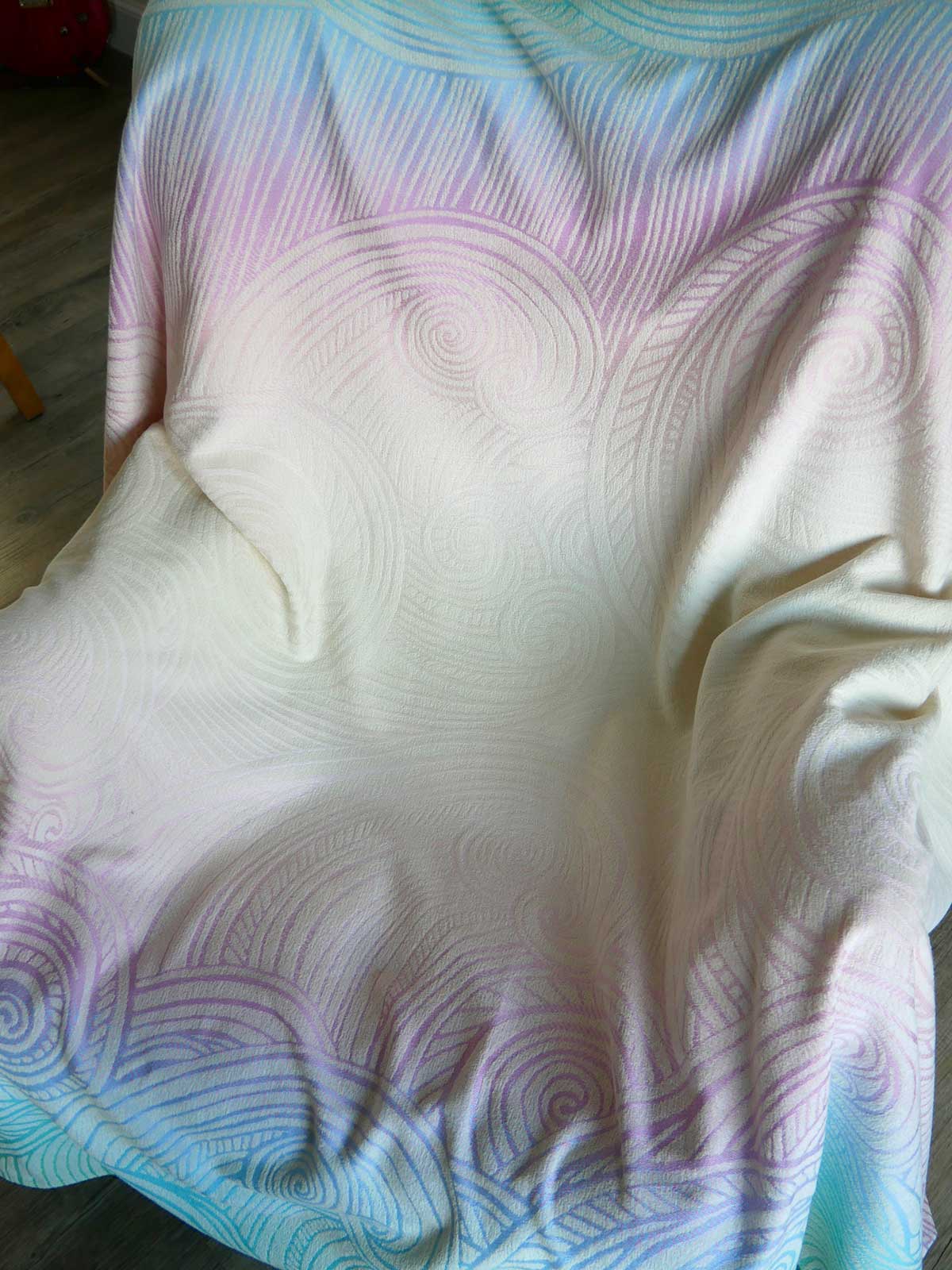 Colorful blanket with wave pattern on a wooden floor