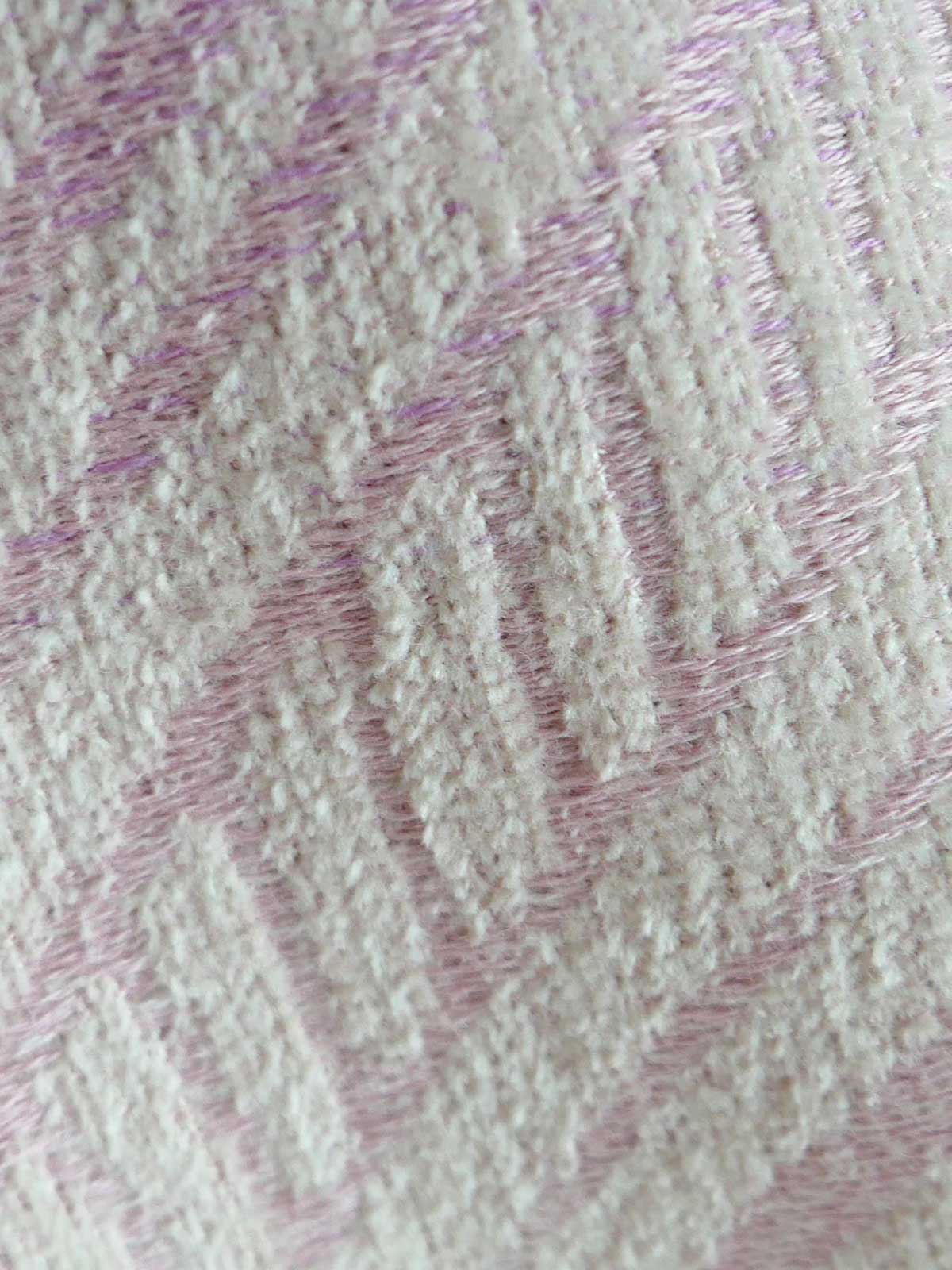 Close-up of textured fabric with wavy pattern in pink on beige background