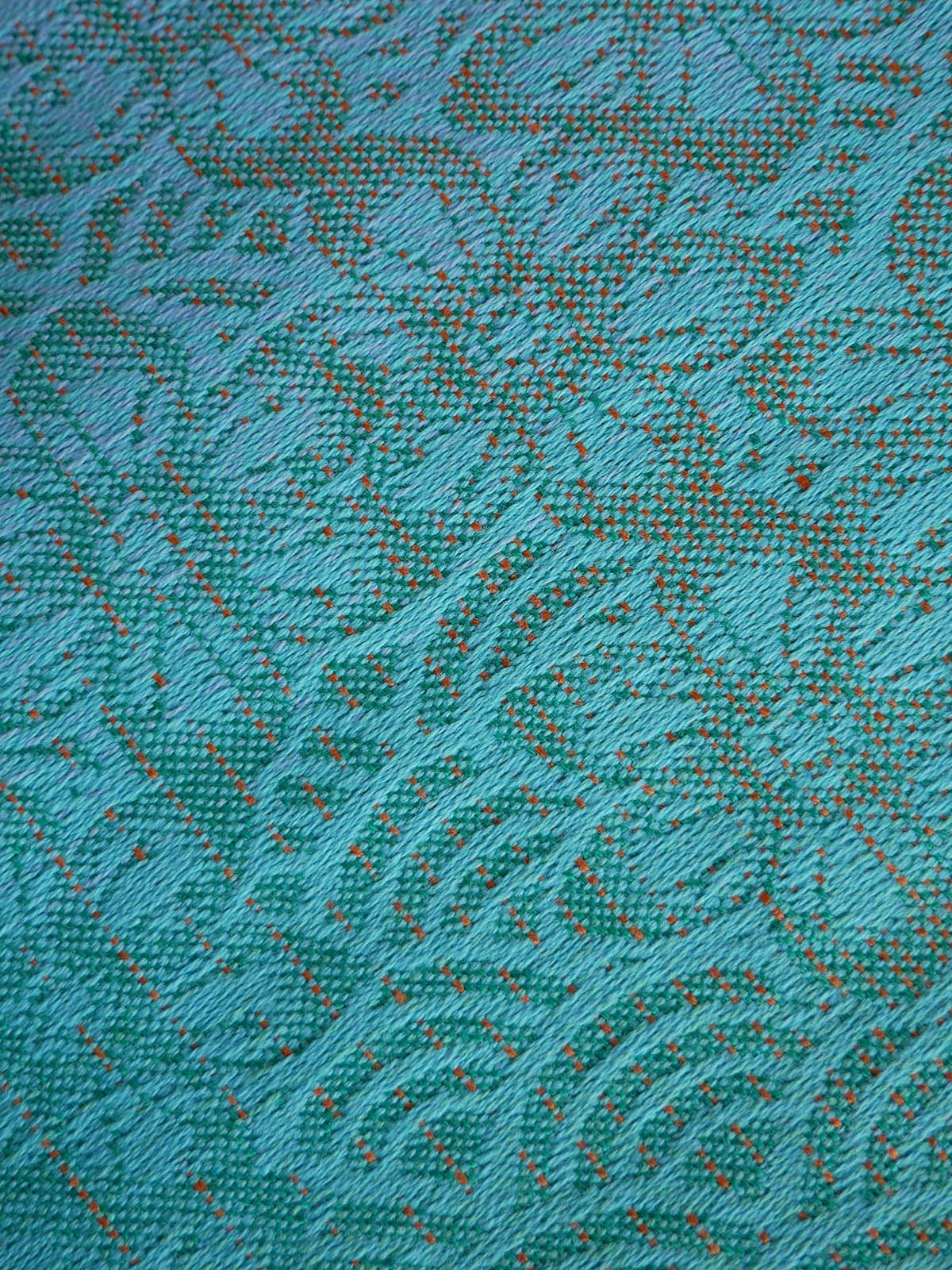 Close-up of a textured teal fabric with a subtle pattern