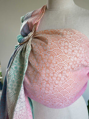 Mannequin wearing a patterned ring sling with a floral design on a neutral background
