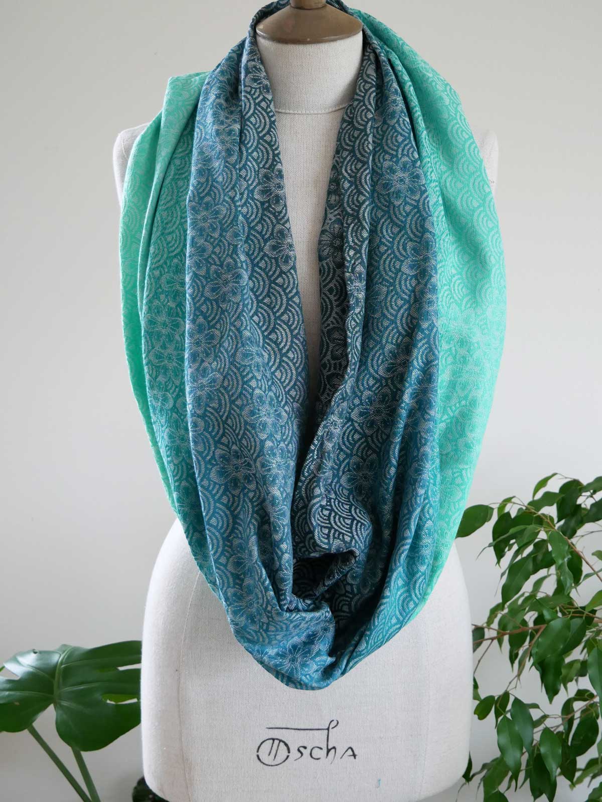 Teal patterned Sekaibloom Wave Infinity Loop on a mannequin with a white background