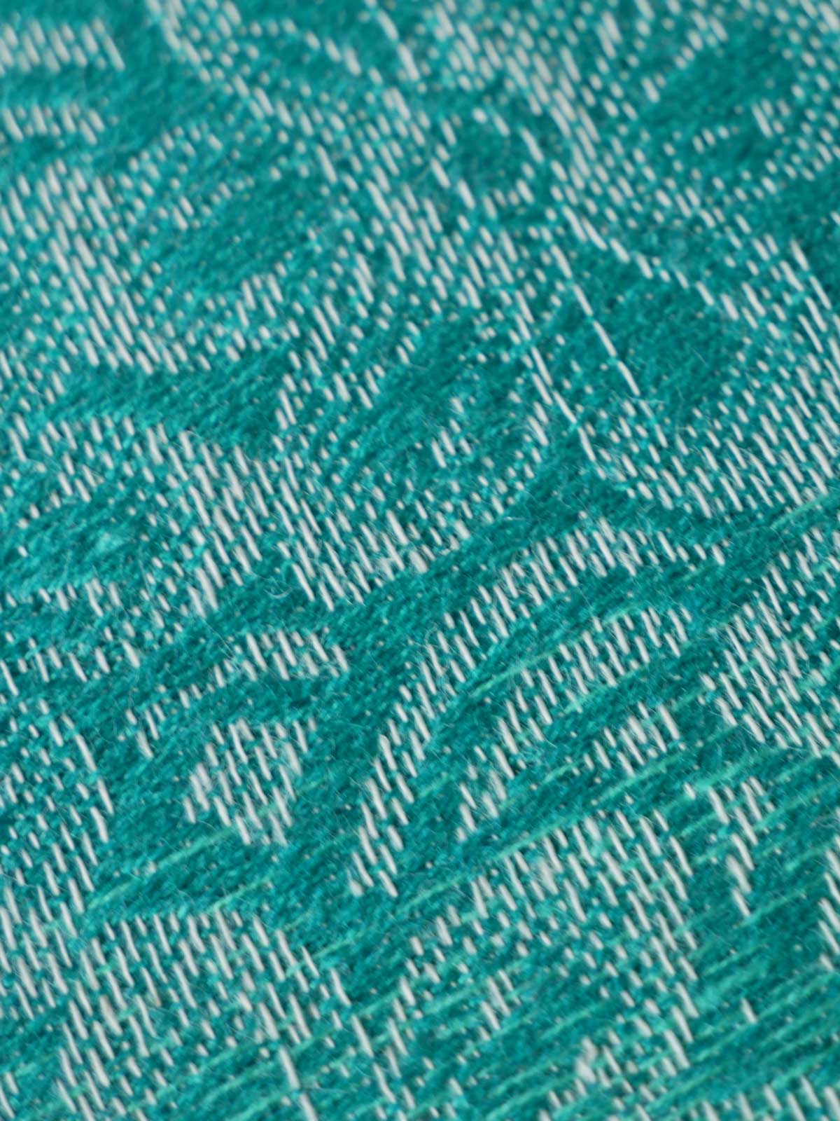 Close-up of teal fabric with a subtle pattern