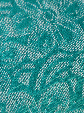 Close-up of teal fabric with a subtle pattern