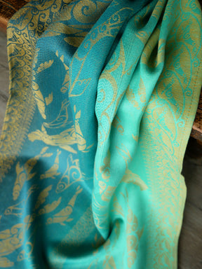 Teal fabric with gold patterns on a wooden surface