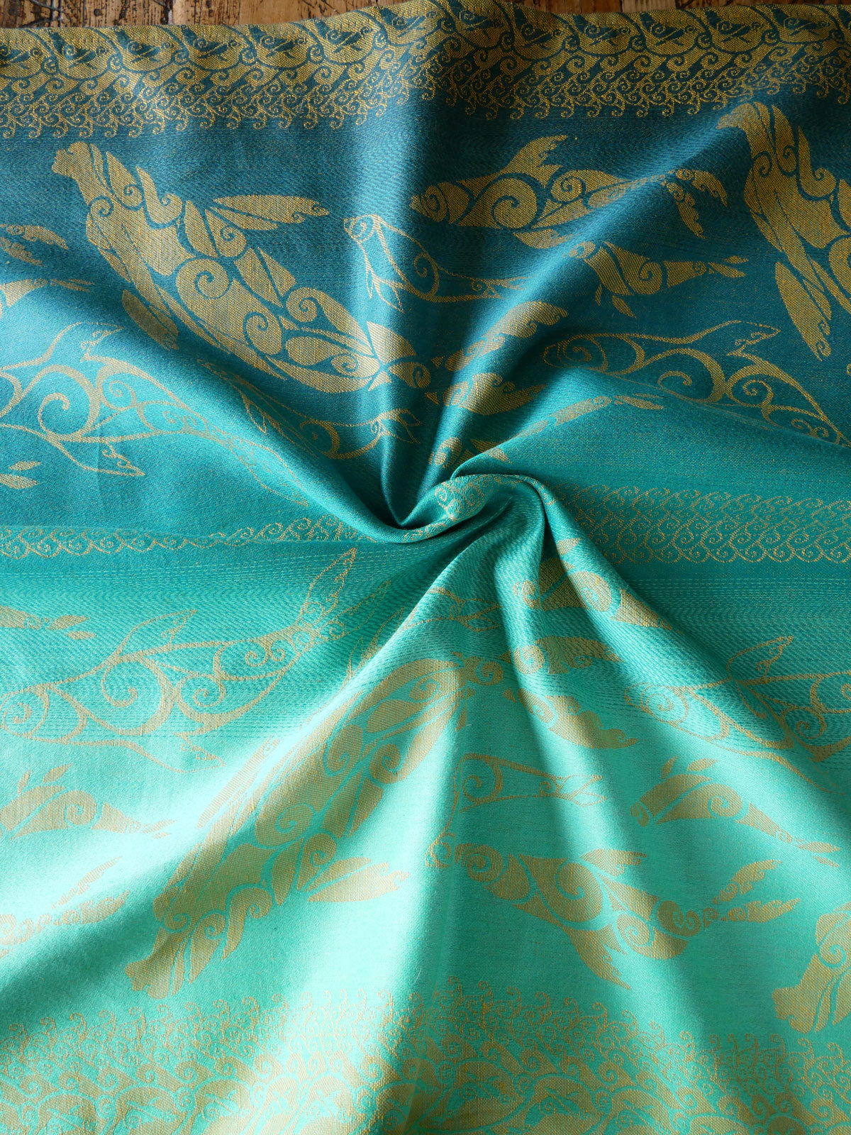 Teal fabric with gold selkies pattern