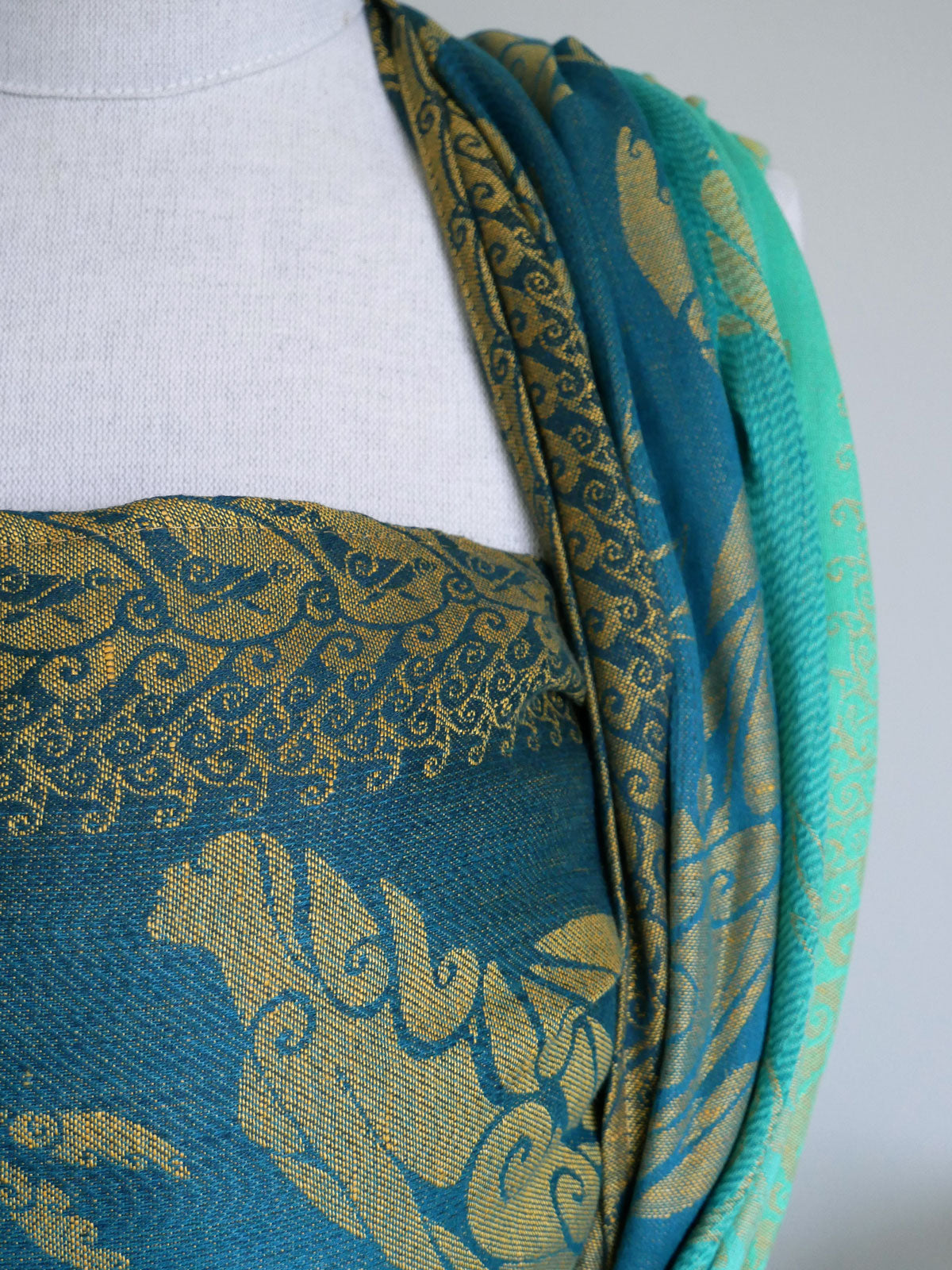 Blue and green patterned fabric on a mannequin with a white background
