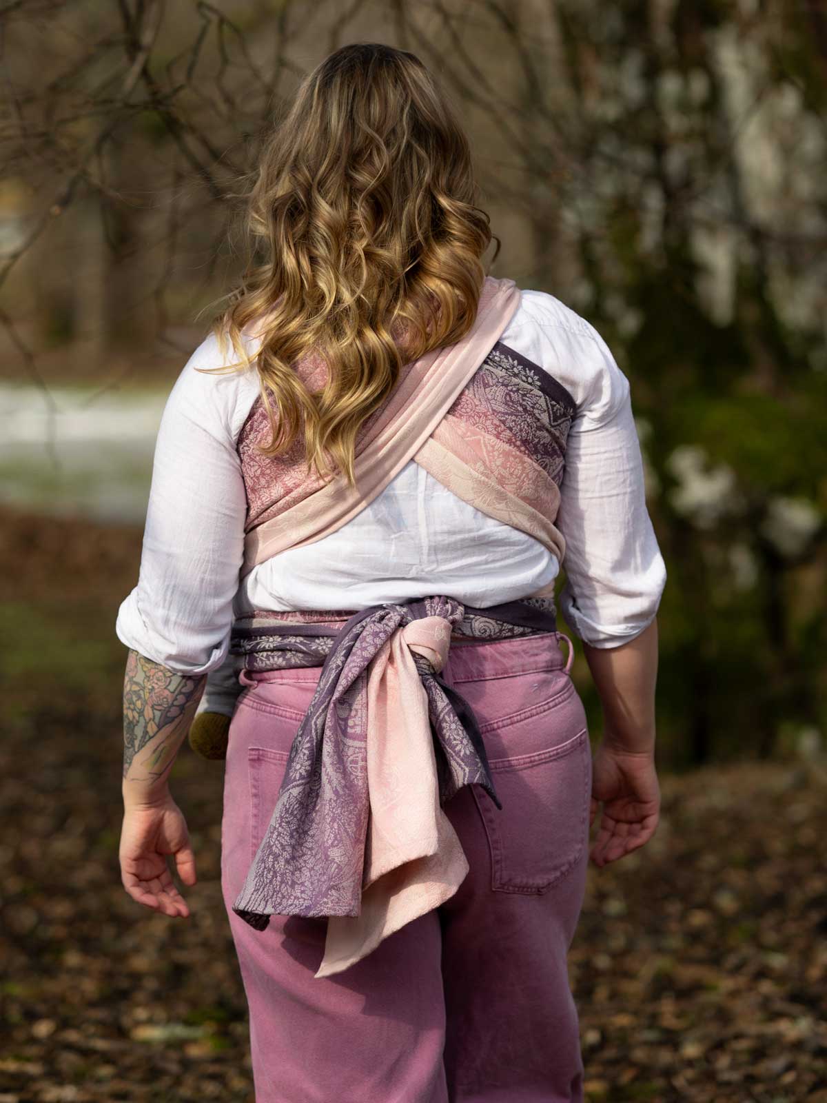 Person wearing a pink and purple woven wrap outdoors