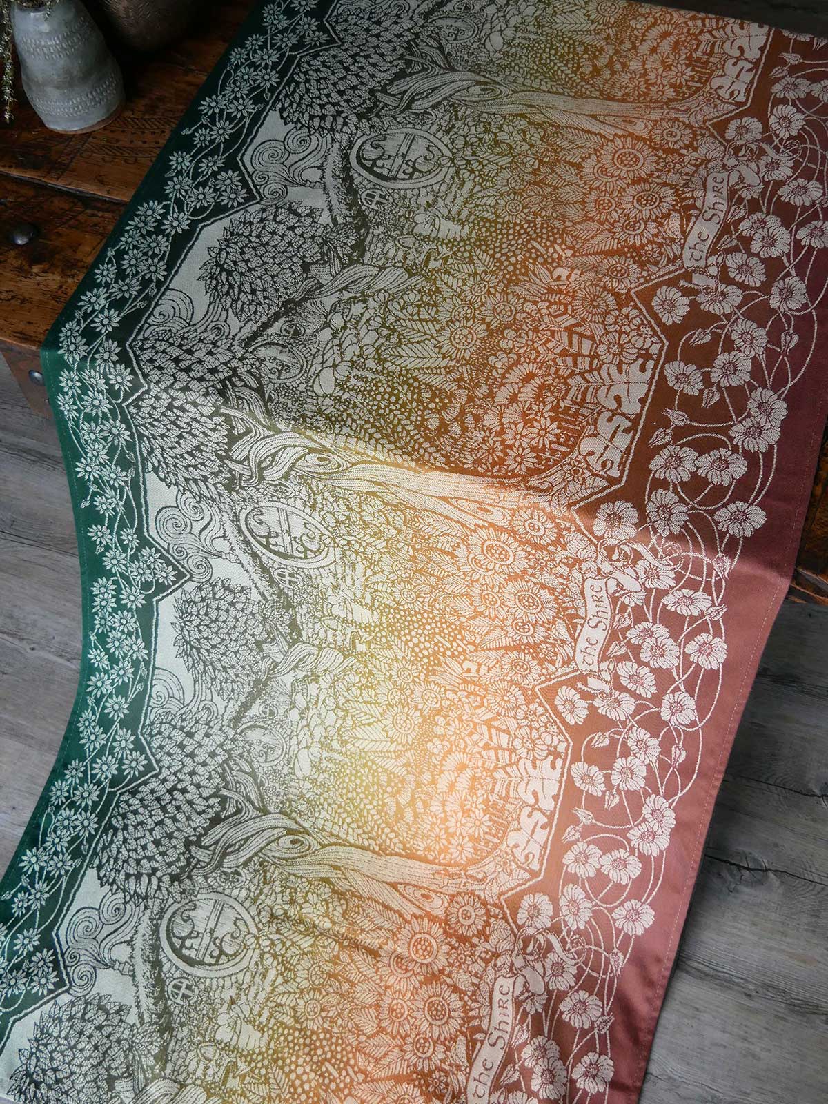 Gradient fabric with patterns of the Shire on a wooden surface