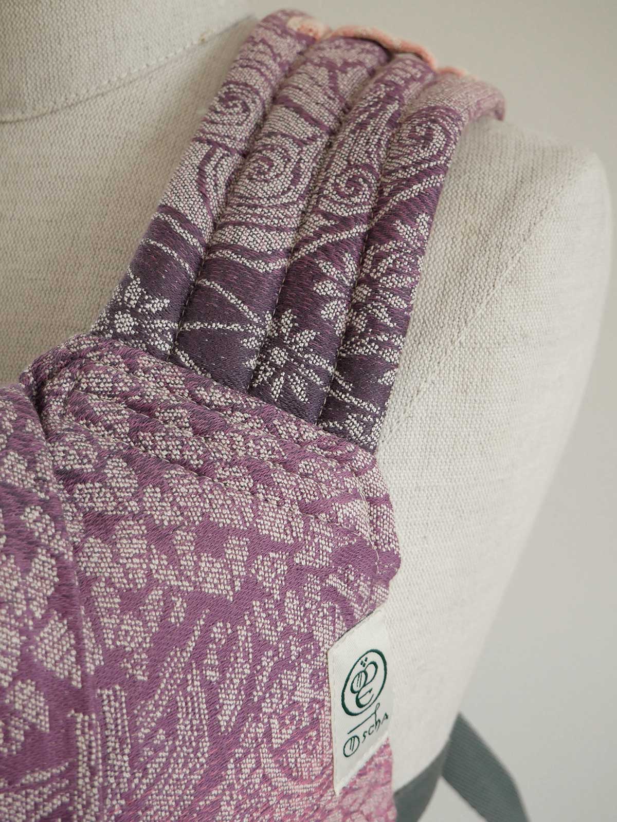 Purple patterned sling on a mannequin with a visible brand logo.