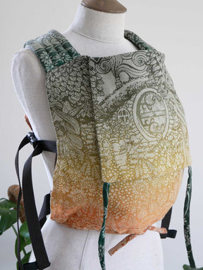 Mannequin wearing a patterned baby carrier with a white background